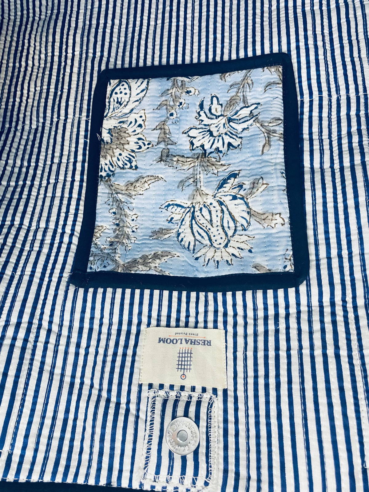Close-up of inside of the bag blue and white striped with a floral compartment
