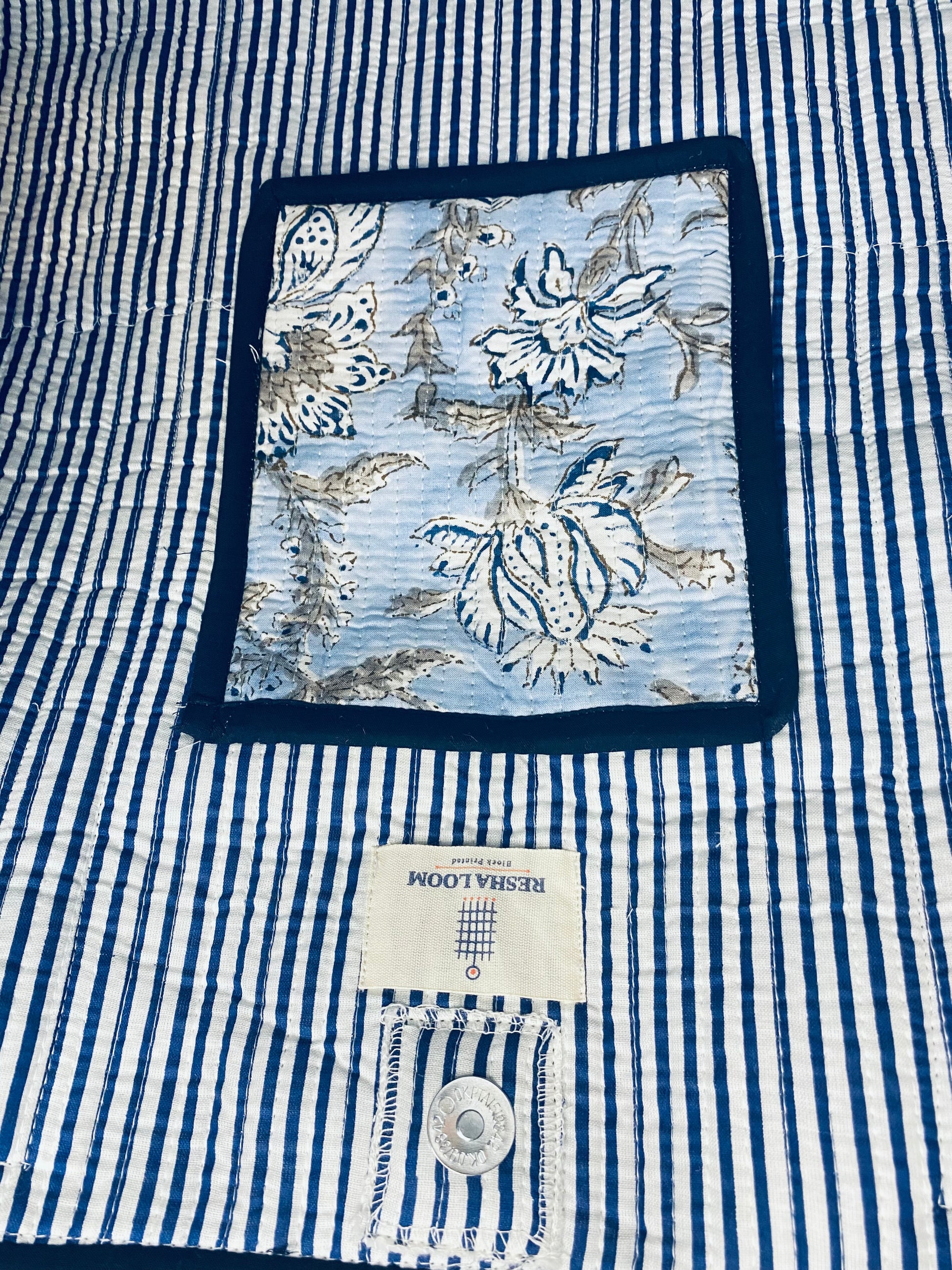 Close-up of inside of the bag blue and white striped with a floral compartment 